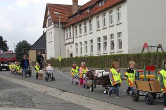 Kinder und MitarbeiterInnen ziehen mit Bollerwagen voller Spielzeug zum neuen Gebäude. Foto: Pohlmann/Caritas Kinder und MitarbeiterInnen ziehen mit Bollerwagen voller Spielzeug zum neuen Gebäude. Foto: Pohlmann/Caritas