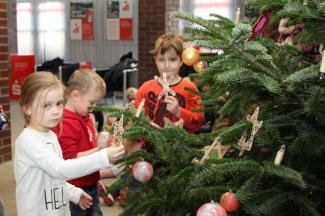Die Kinder der Caritas-Kita Maria-Königin aus Ahrbergen schmücken den Weihnachtsbaum in der Sparkasse-Geschäftsstelle in Giesen. Foto: Pohlmann/Caritas Die Kinder der Caritas-Kita Maria-Königin aus Ahrbergen schmücken den Weihnachtsbaum in der Sparkasse-Geschäftsstelle in Giesen. Foto: Pohlmann/Caritas